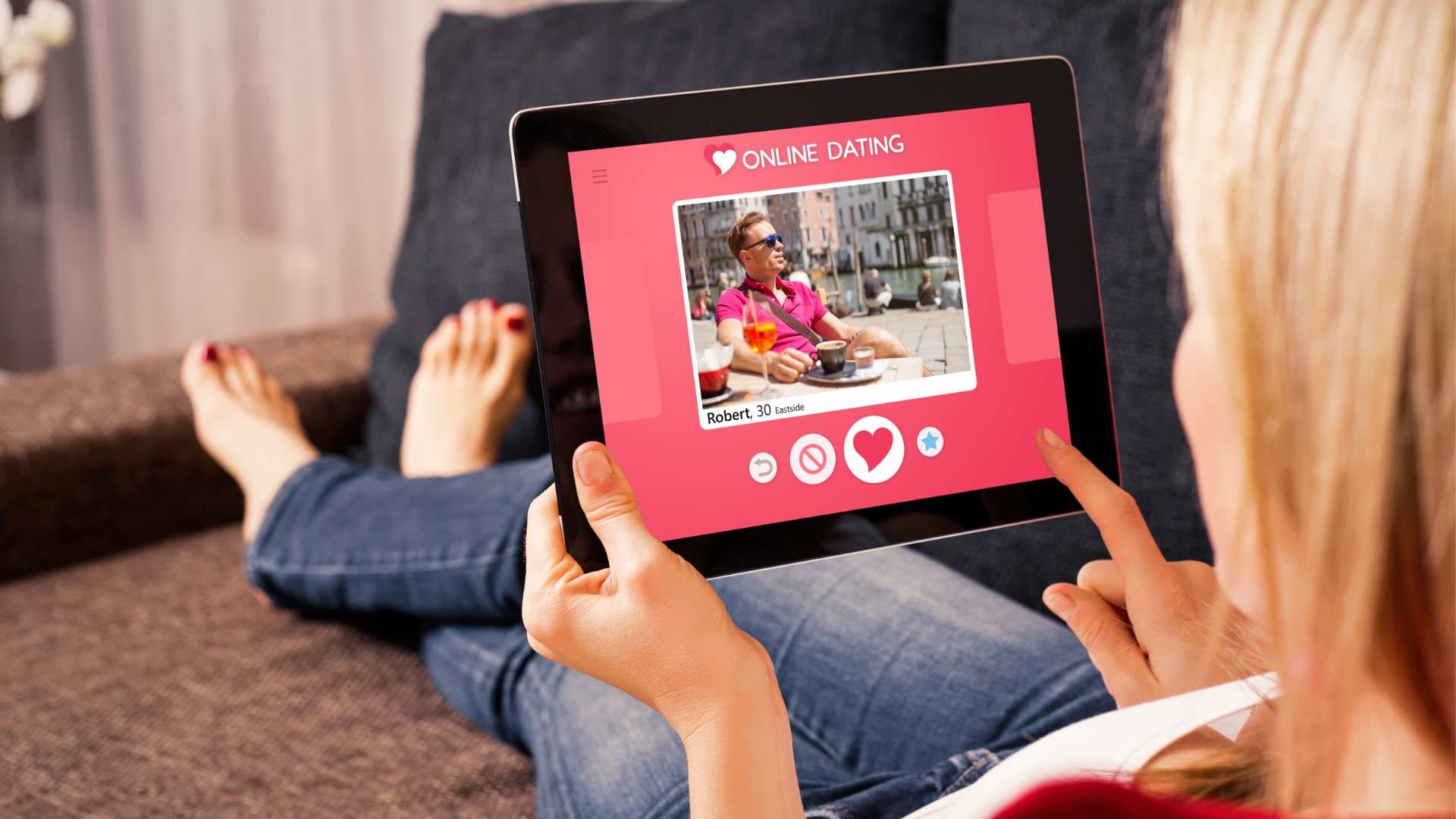 Bir kadın, tabletinde online flört uygulaması arayüzünü inceliyor